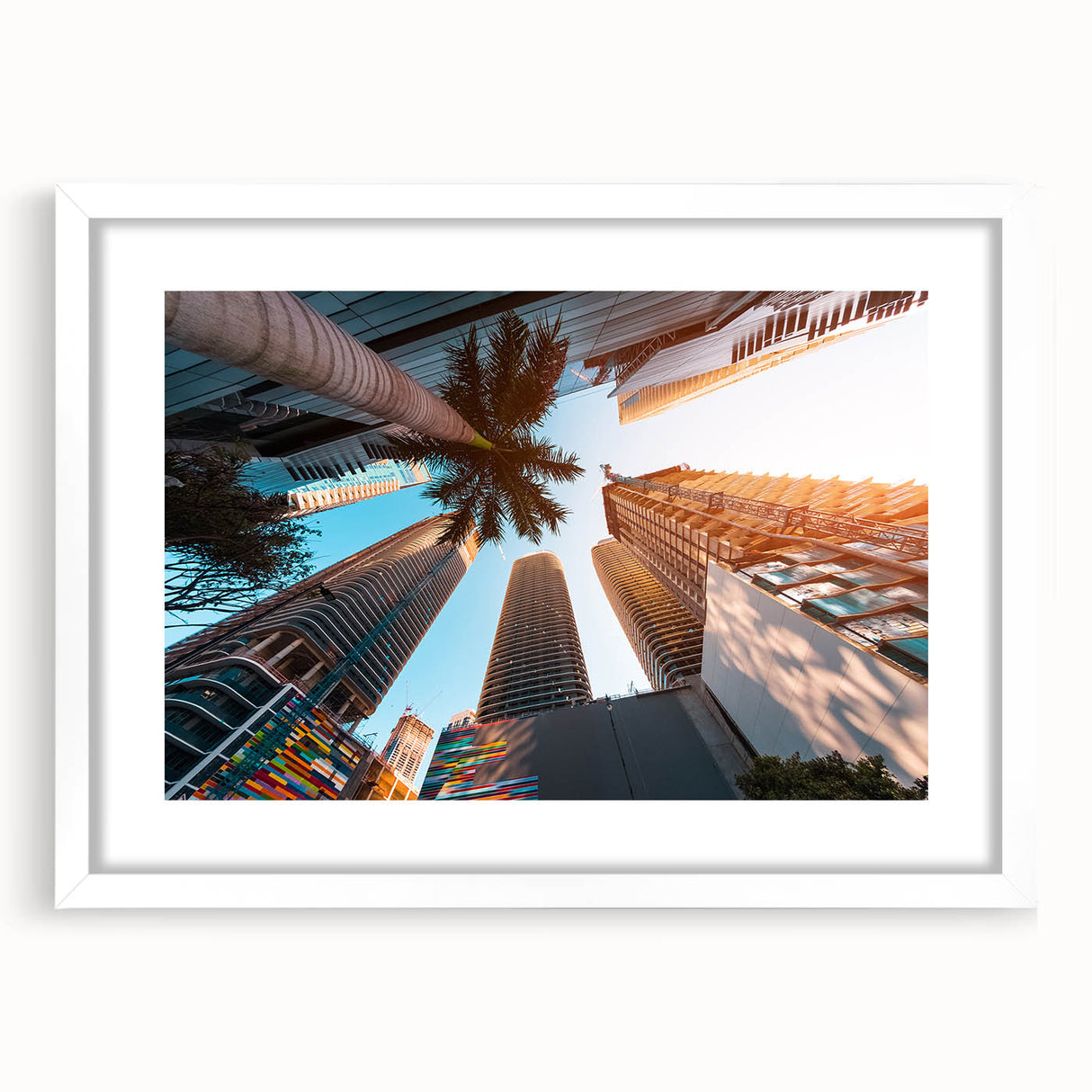 Abstract art print of Miami skyline in muted blue and pink tones on a white framed canvas, ideal for dining room decor.