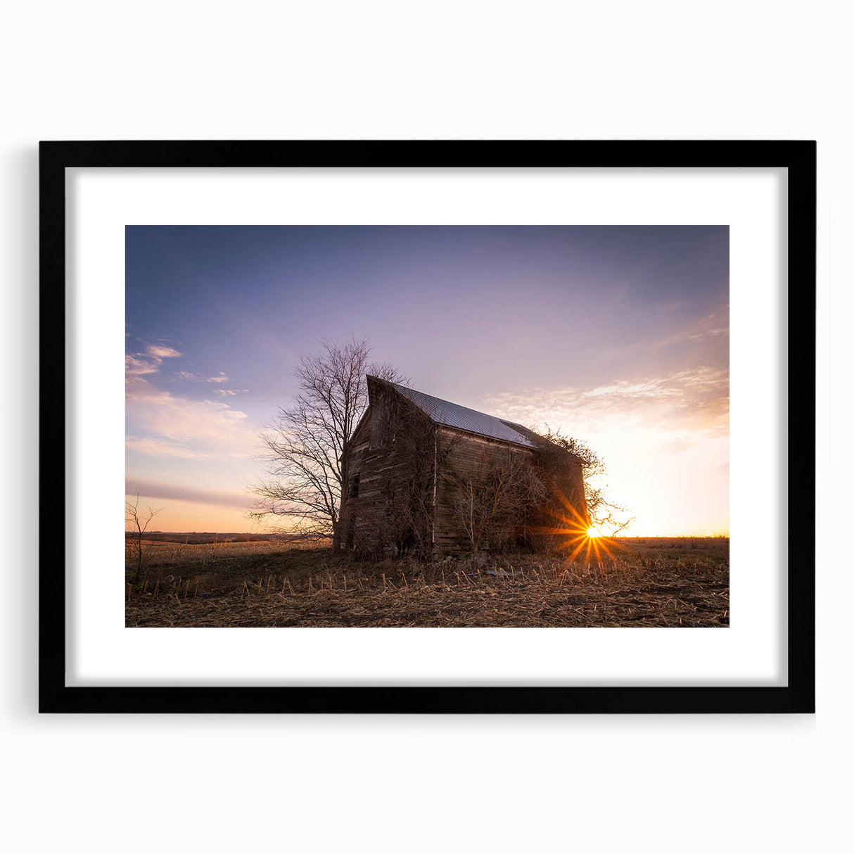 Colorful abstract art print of a textured Nebraska landscape in a black frame, ideal for living room decor.
