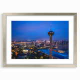 Textured abstract art print of San Antonio skyline in muted earth tones, framed in silver, ideal for modern bedroom ambiance.