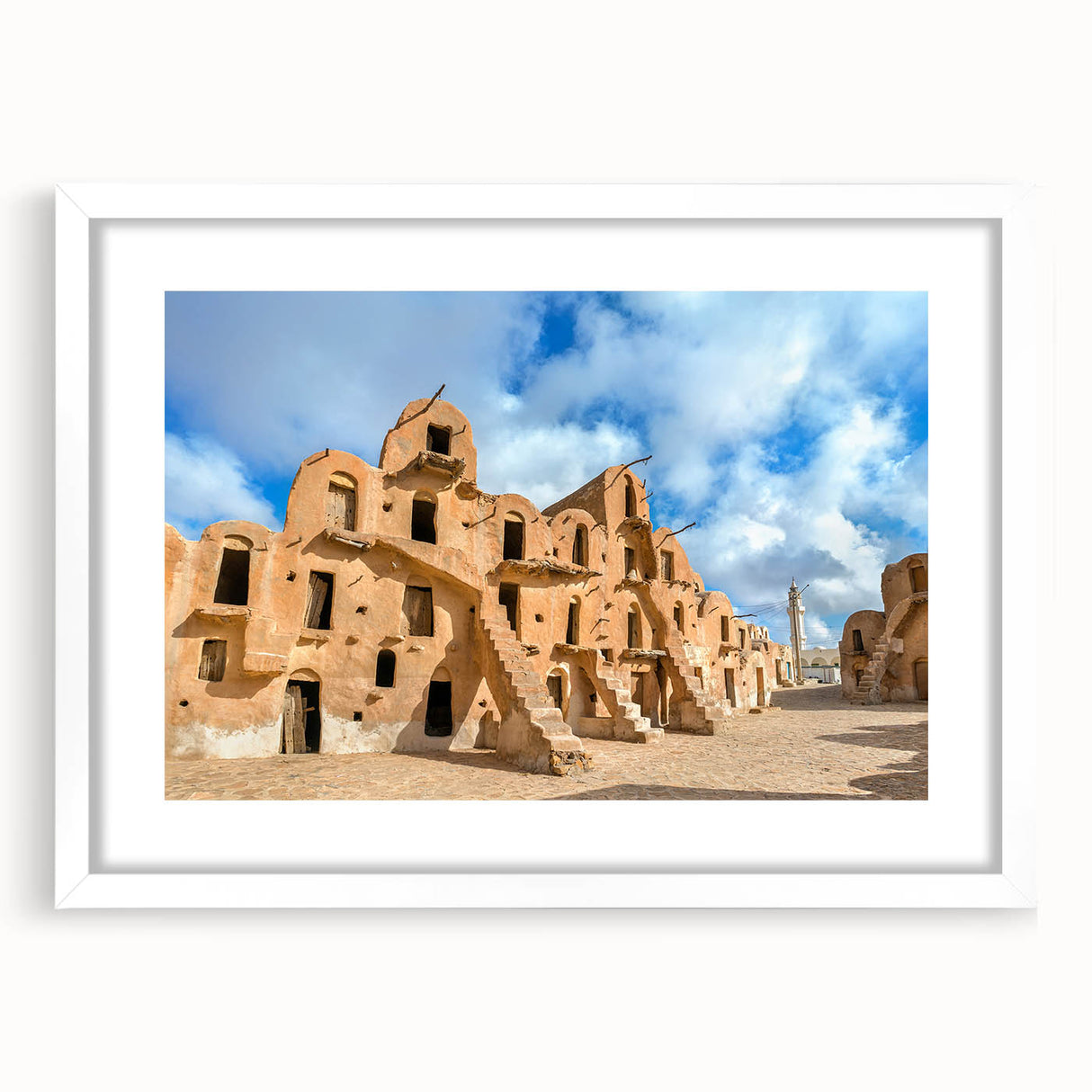 Abstract art print of a Tunisian landscape in muted earth tones on a framed white mat, ideal for dining room decor.