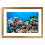 Textured abstract art print of the Great Barrier Reef in blue and green shades, framed in gold, suitable for bedroom decor.