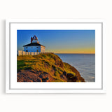 Abstract art print of Newfoundland scenery in muted blue and green tones, framed with a white mat.