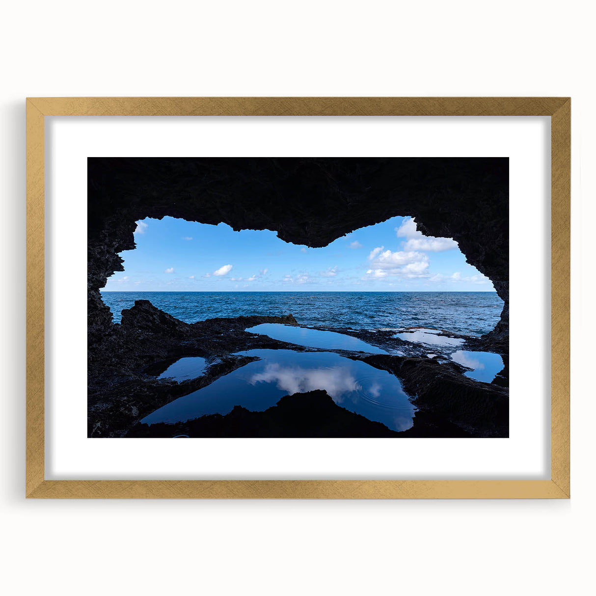 Abstract art print of a Caribbean scenery in muted blue and green tones on a framed gold mat, suitable for dining room decor.