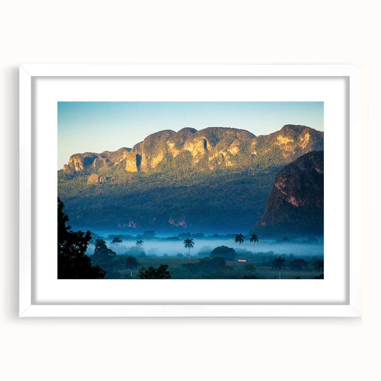 Textured abstract art print depicting a Caribbean scene in muted blue and green tones, framed with a white mat.