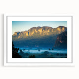 Textured abstract art print depicting a Caribbean scene in muted blue and green tones, framed with a white mat.