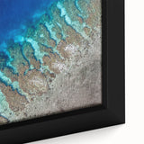 Close-up of textured black wall art featuring a vibrant, colorful Central American scenery on a framed canvas.