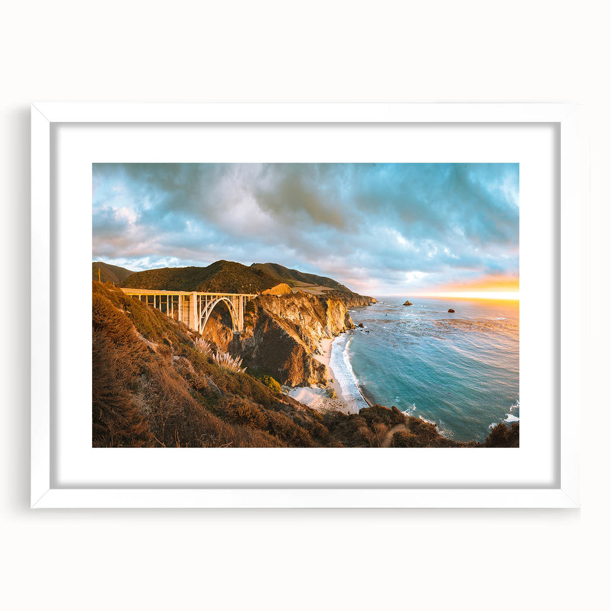 Abstract art print of Big Sur in muted blue and green tones, framed in white, ideal for dining room decor.