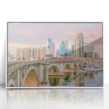 Acrylic print of Minneapolis skyline in muted gray and blue tones, framed in white, suitable for modern nursery decor.