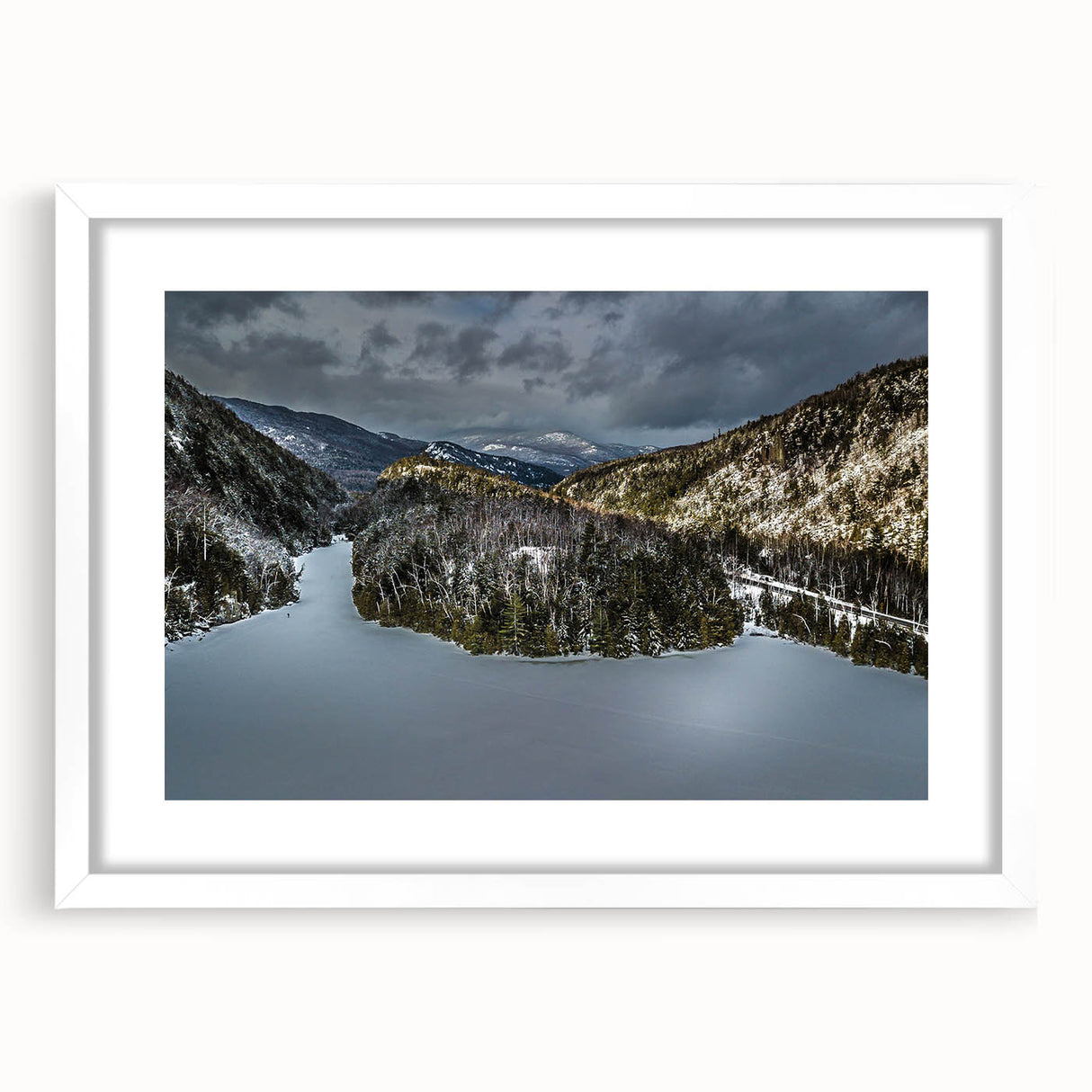 Abstract art print of Adirondack scenery in muted green and blue tones, framed in white, suitable for dining room decor.