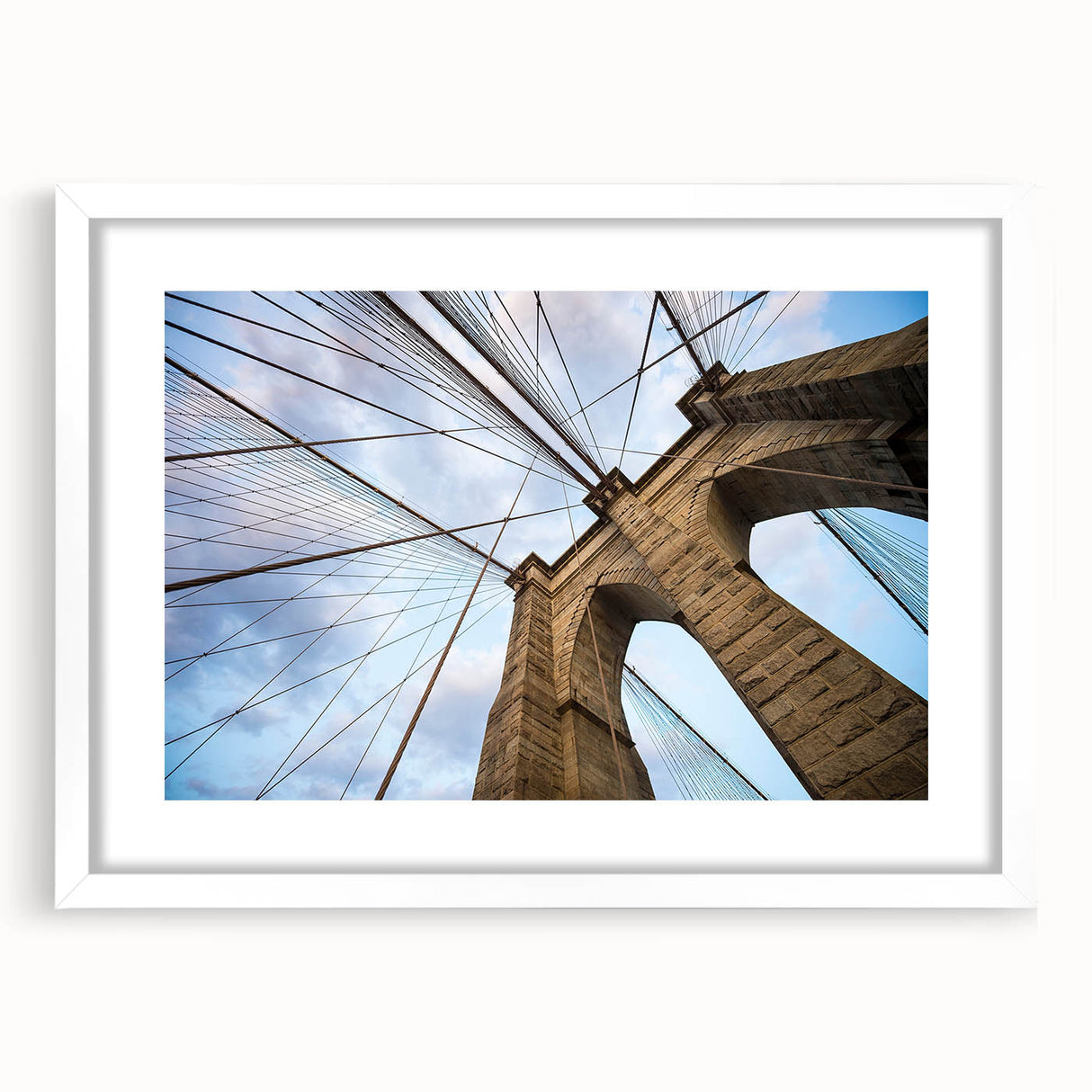 Abstract art print of the Brooklyn Bridge in muted gray and blue tones, framed with a white mat.