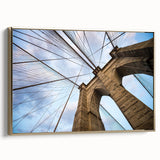 Framed canvas featuring a vintage poster art style of the Brooklyn Bridge in black and gold tones.