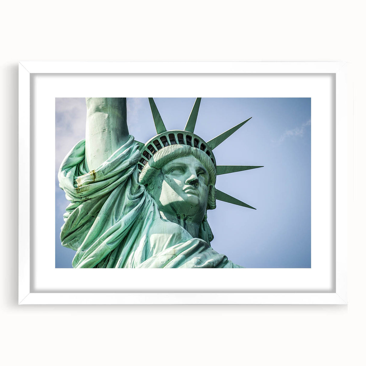 Abstract art print of the Statue of Liberty in muted blue tones, framed with a white mat, suitable for dining room decor.