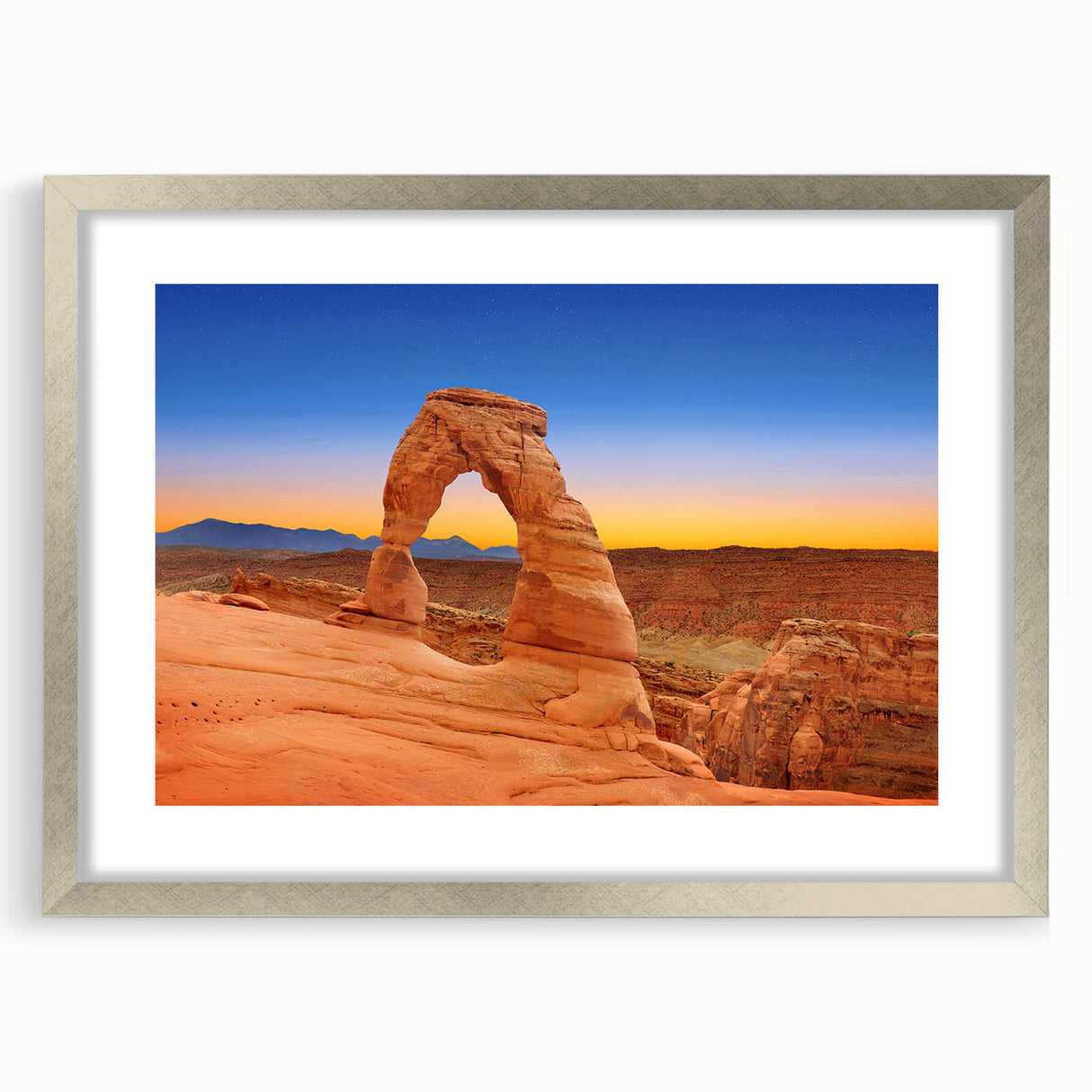 Textured art print depicting abstract Arches National Park scenery in earth tones on a framed silver mat.