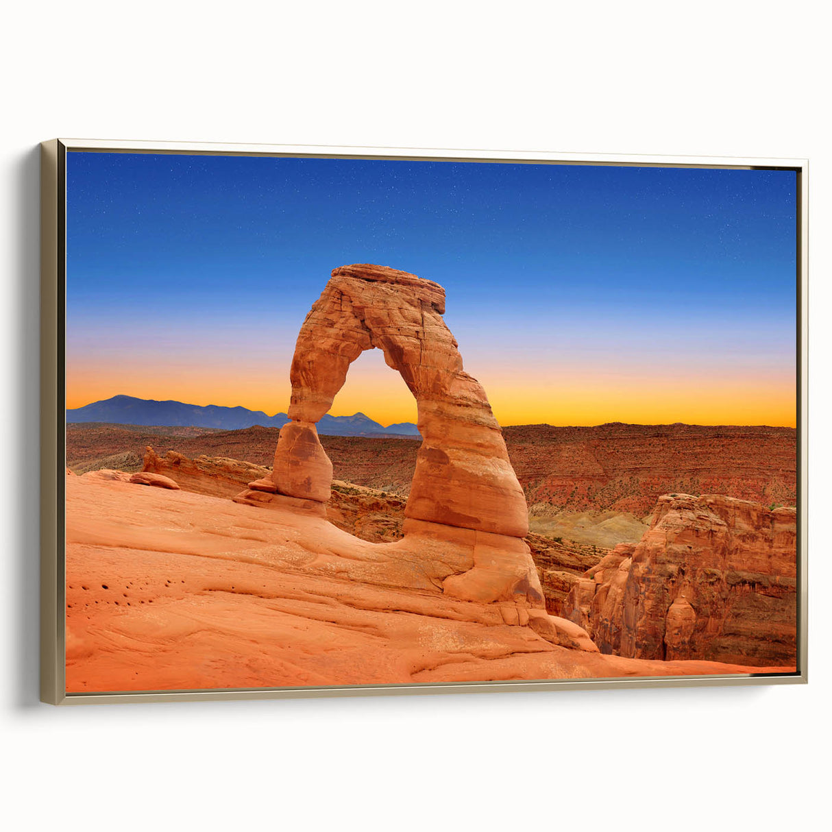 Framed canvas wall art featuring a landscape painting of Arches National Park in Utah, with earthy red and muted gold tones.