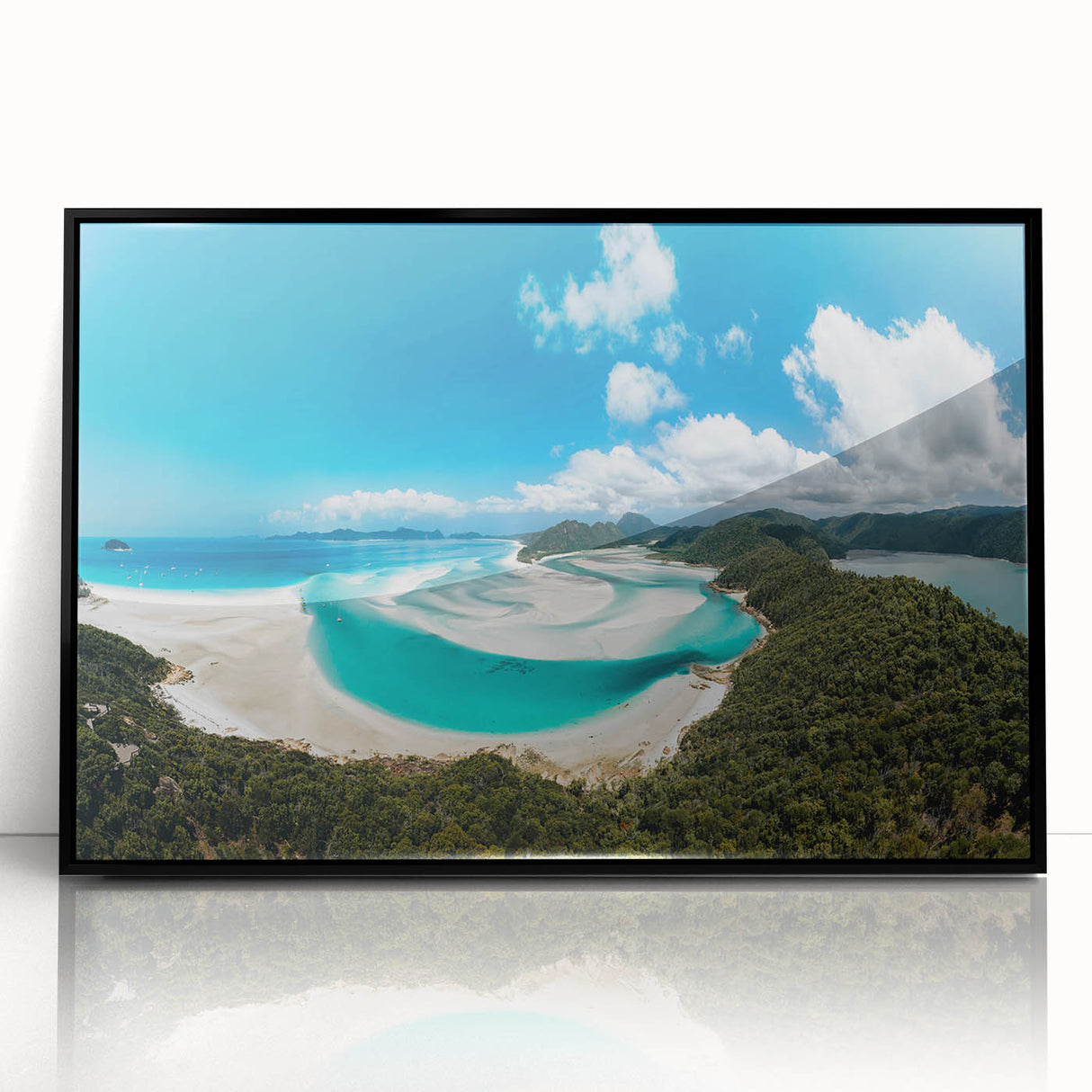 Large abstract wall art of the Great Barrier Reef in vibrant blue and green tones, framed in black acrylic.
