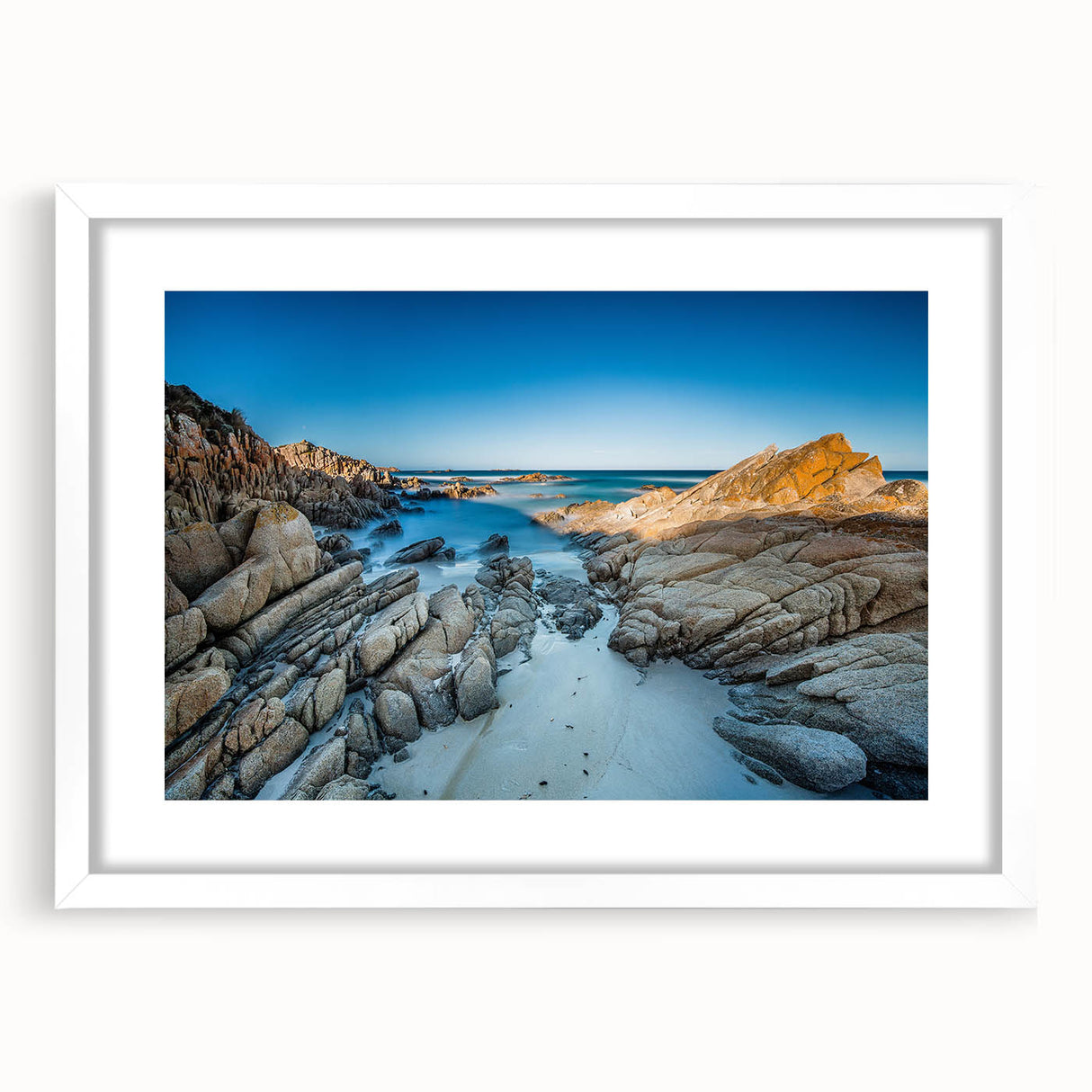 Extra large abstract art print of Tasmania scenery in muted earth tones on a textured canvas, framed in white.