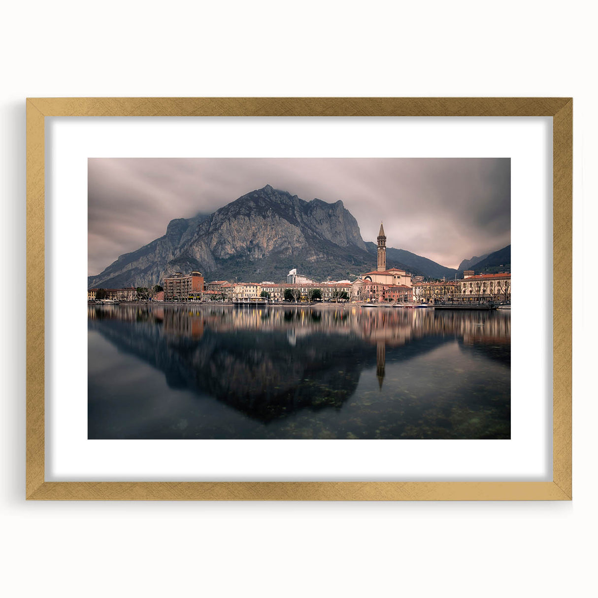 Abstract art print of Lake Como with muted blue and green tones on a framed gold mat, suitable for dining room decor.