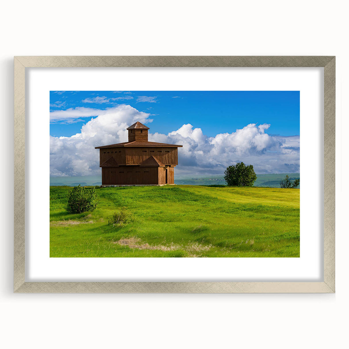 Textured art print of North Dakota scenery in muted earth tones on a framed silver mat, suitable for bedroom decor.