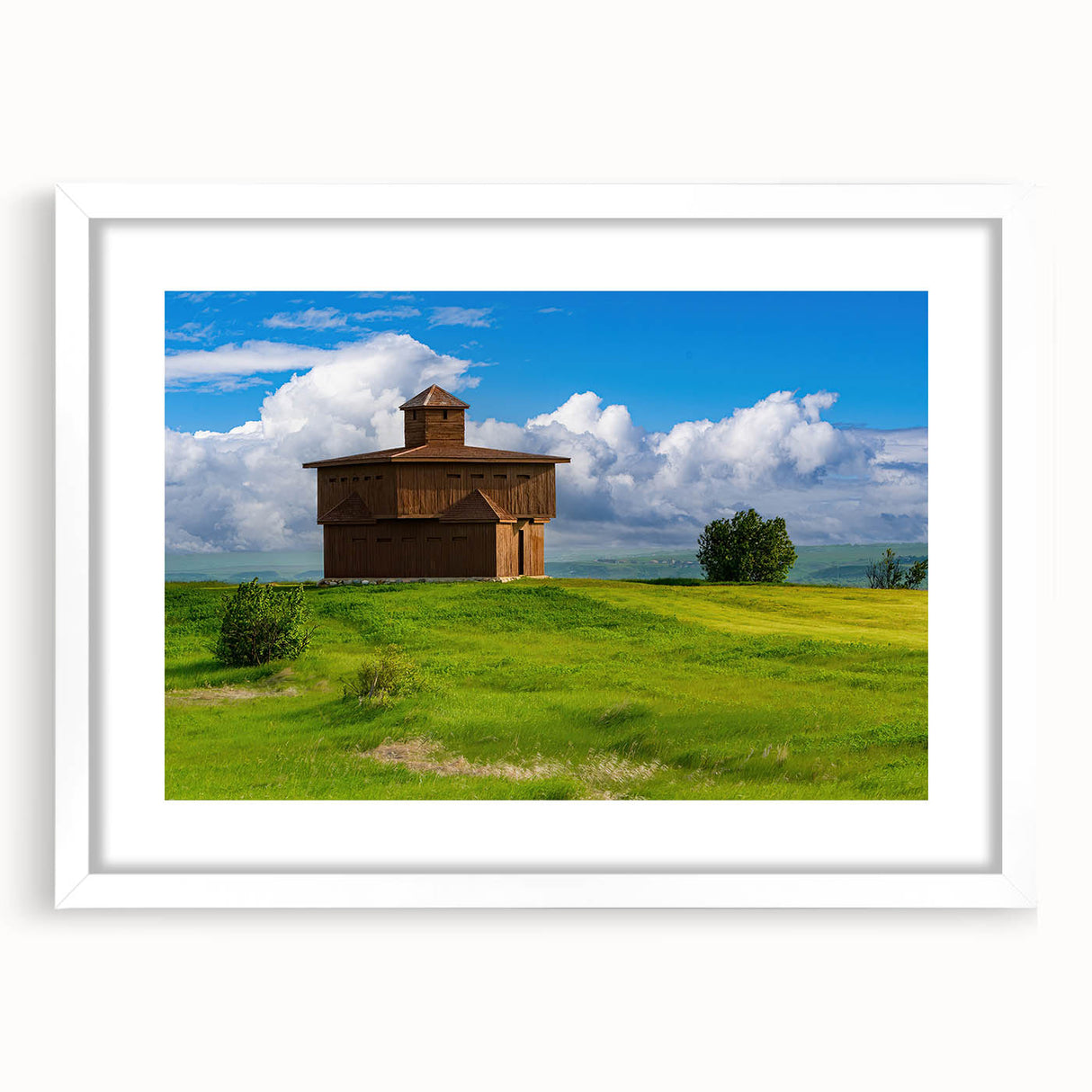 Abstract art print of North Dakota scenery in muted earth tones on a framed white mat, suitable for dining room decor.