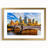 Textured abstract art print of Melbourne scenery in muted gold and blue tones, framed with a gold mat, ideal for bedroom art.