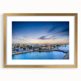 Abstract art print of a Caribbean scene in muted blue and green tones, framed in gold, ideal for dining room decor.