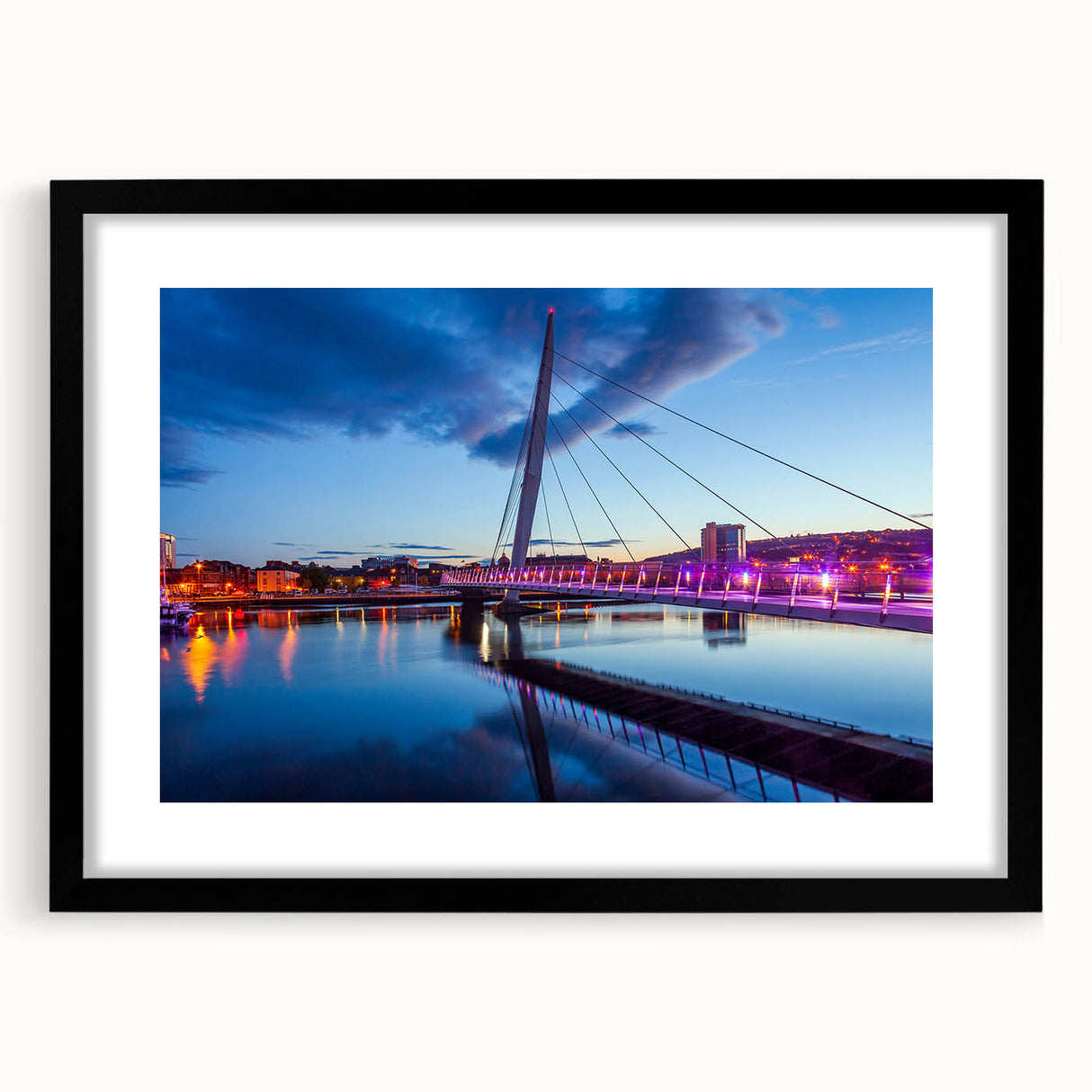 Abstract art print featuring a colorful, textured landscape of Wales in a black frame with mat.