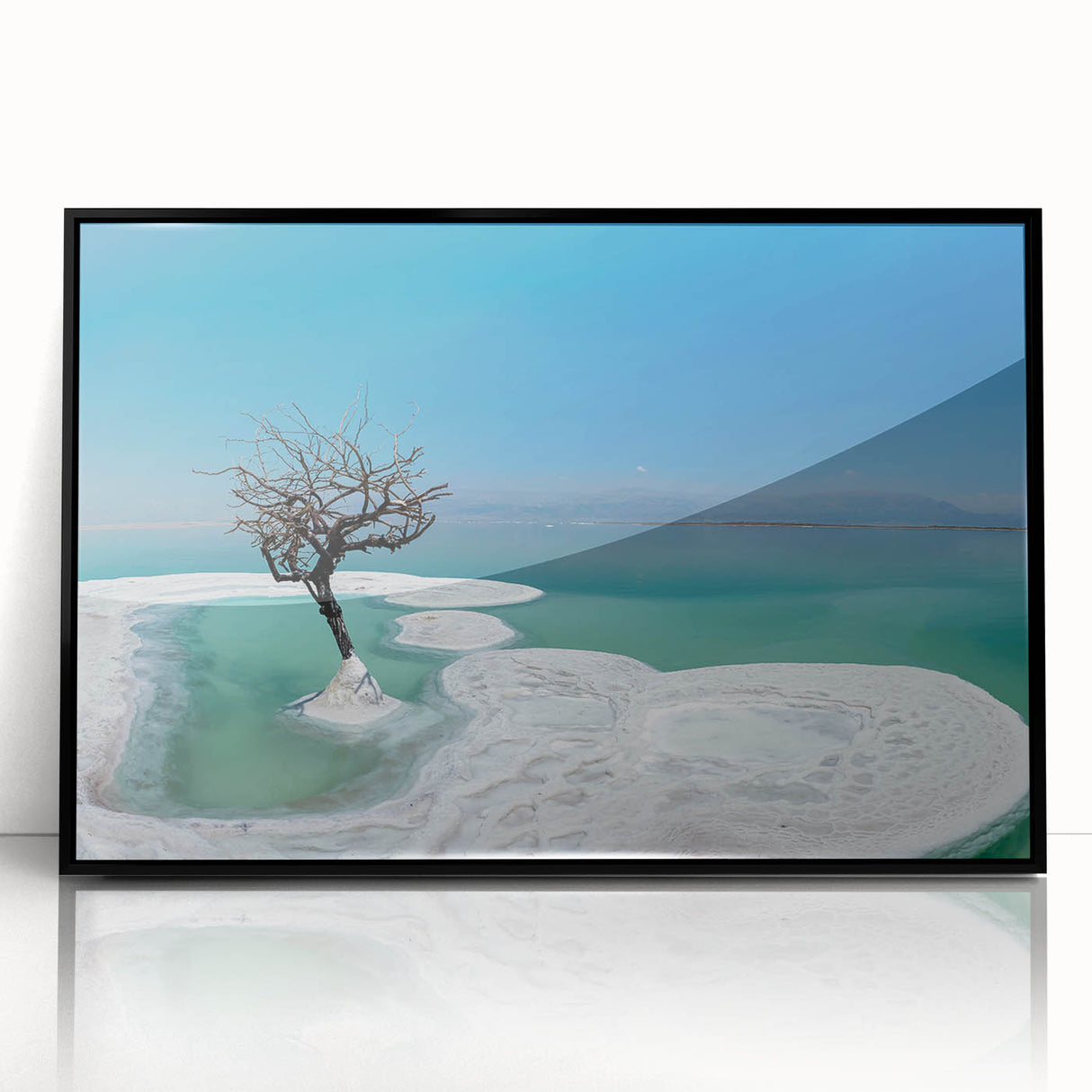 Large abstract wall art of the Dead Sea in muted blue and white tones, framed in black acrylic.