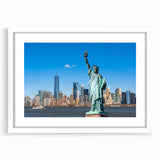 Abstract art print of the Statue of Liberty in muted blue and green tones on a white framed poster.
