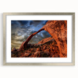 Textured art depicting Arches National Park in muted earth tones on a framed silver mat, suitable for bedroom decor.
