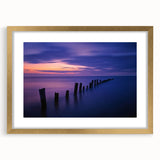 Elegant gold-framed landscape artwork showcasing serene beach scenery with soft waves and sandy shores, complete with a sophisticated mat for added depth. Ideal for home decor and coastal-themed interiors.