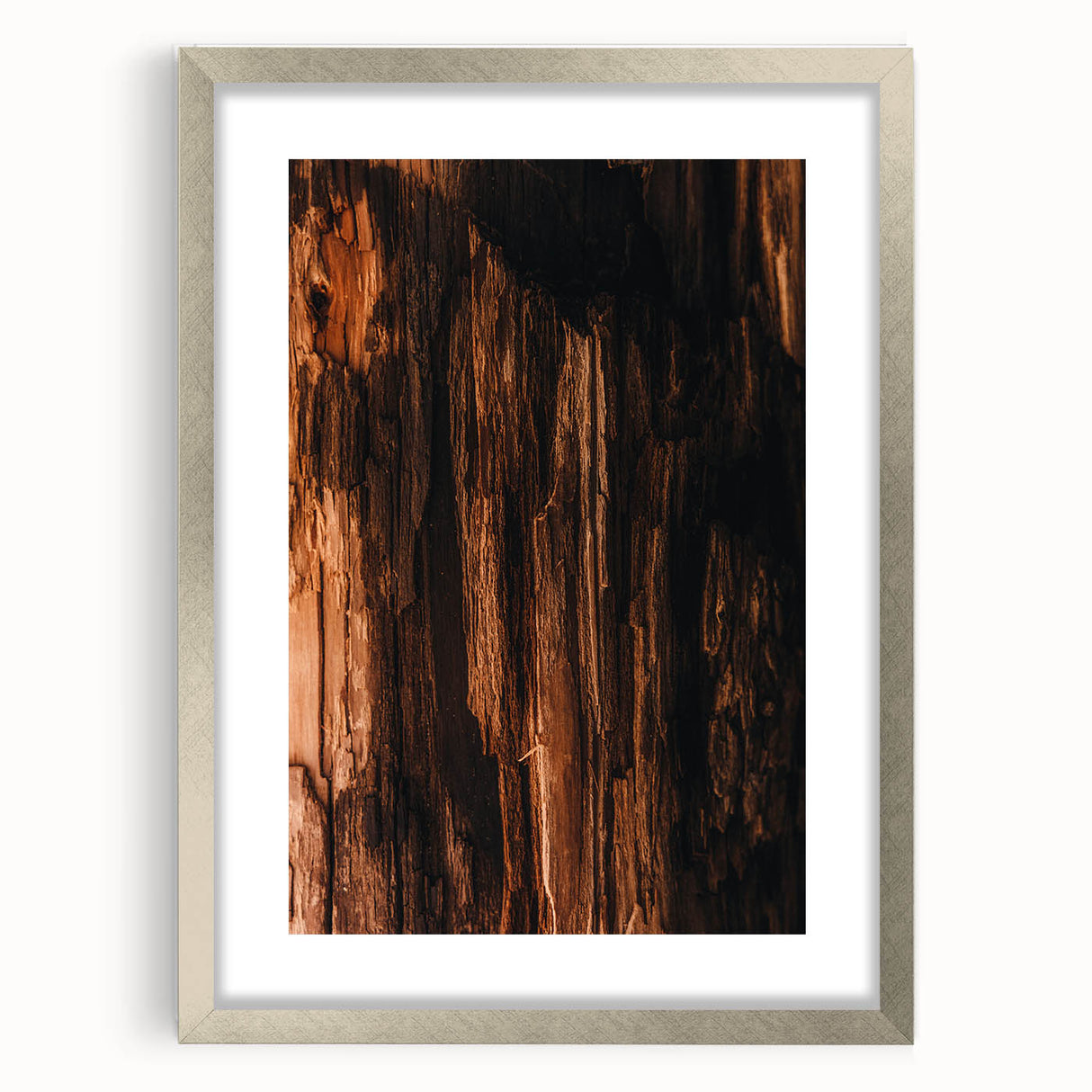 Textured abstract art print in warm orange and brown tones, framed in silver, ideal for bedroom wall decor.