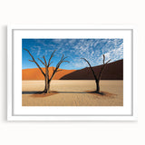 Desert landscape framed artwork with a white mat, showcasing warm tones of orange and brown in a serene desert scene, perfect for modern home decor.