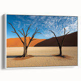 Framed canvas art depicting a serene desert landscape with warm tones of orange and beige, featuring a white frame for a modern touch, ideal for home decor.