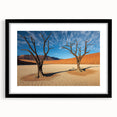 Black-framed landscape artwork depicting a serene desert scene, featuring warm hues of orange and yellow with a textured mat, ideal for home decor enthusiasts.