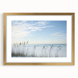 Elegant gold-framed landscape artwork depicting serene beaches with soft waves and a clear sky, perfect for enhancing home decor with a coastal theme.
