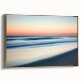 Framed canvas artwork depicting a serene beach landscape with soft golden hues, showcasing gentle waves and palm trees, perfect for coastal home decor.