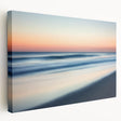Stretched canvas artwork depicting a serene beach landscape with vibrant sunset colors, showcasing gentle waves and palm trees, perfect for coastal home decor.
