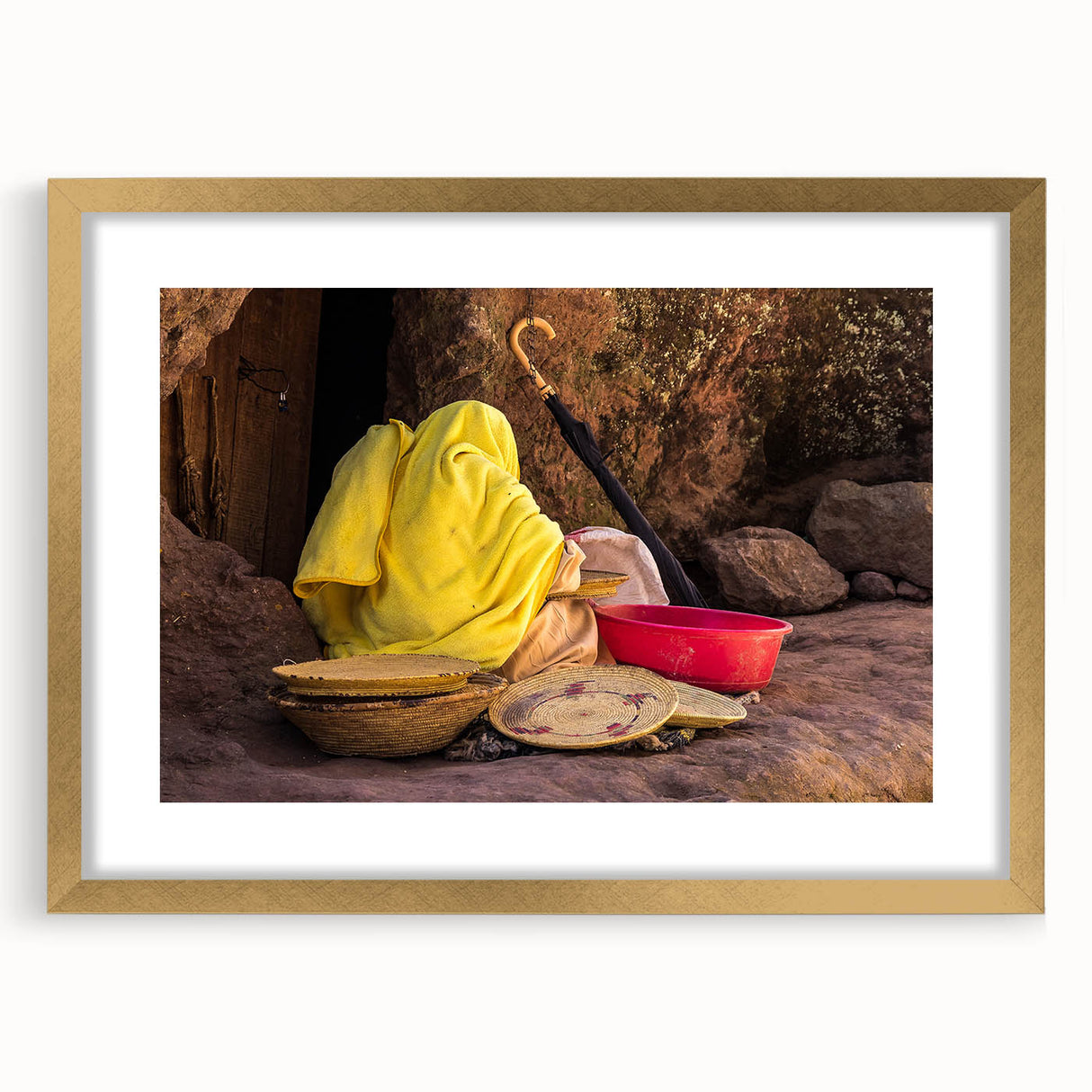 Textured abstract art print depicting Ethiopian scenery in earth tones, framed with a gold mat, suitable for bedroom decor.