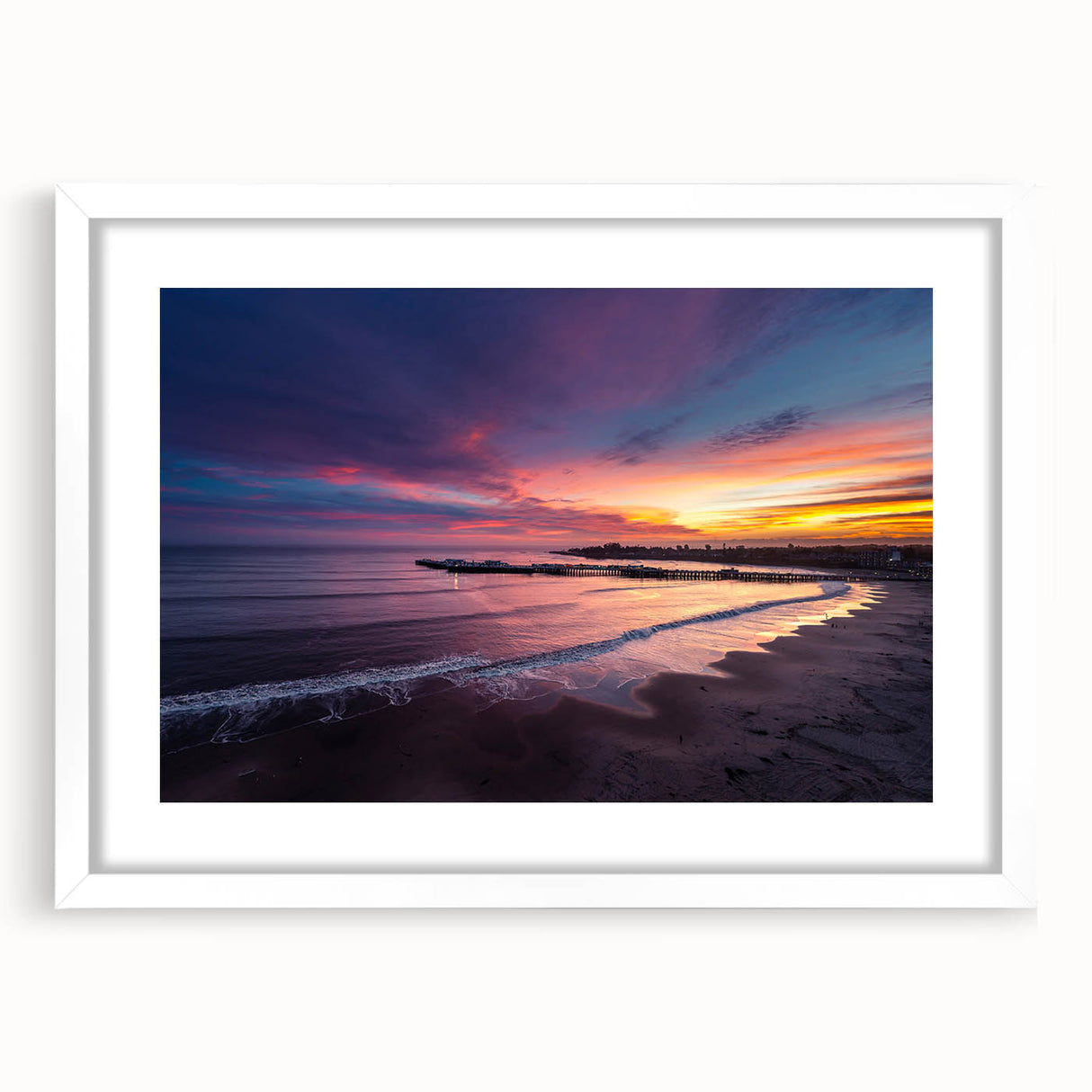 Abstract art print of Santa Cruz featuring vibrant blue and orange hues, framed with a white mat.