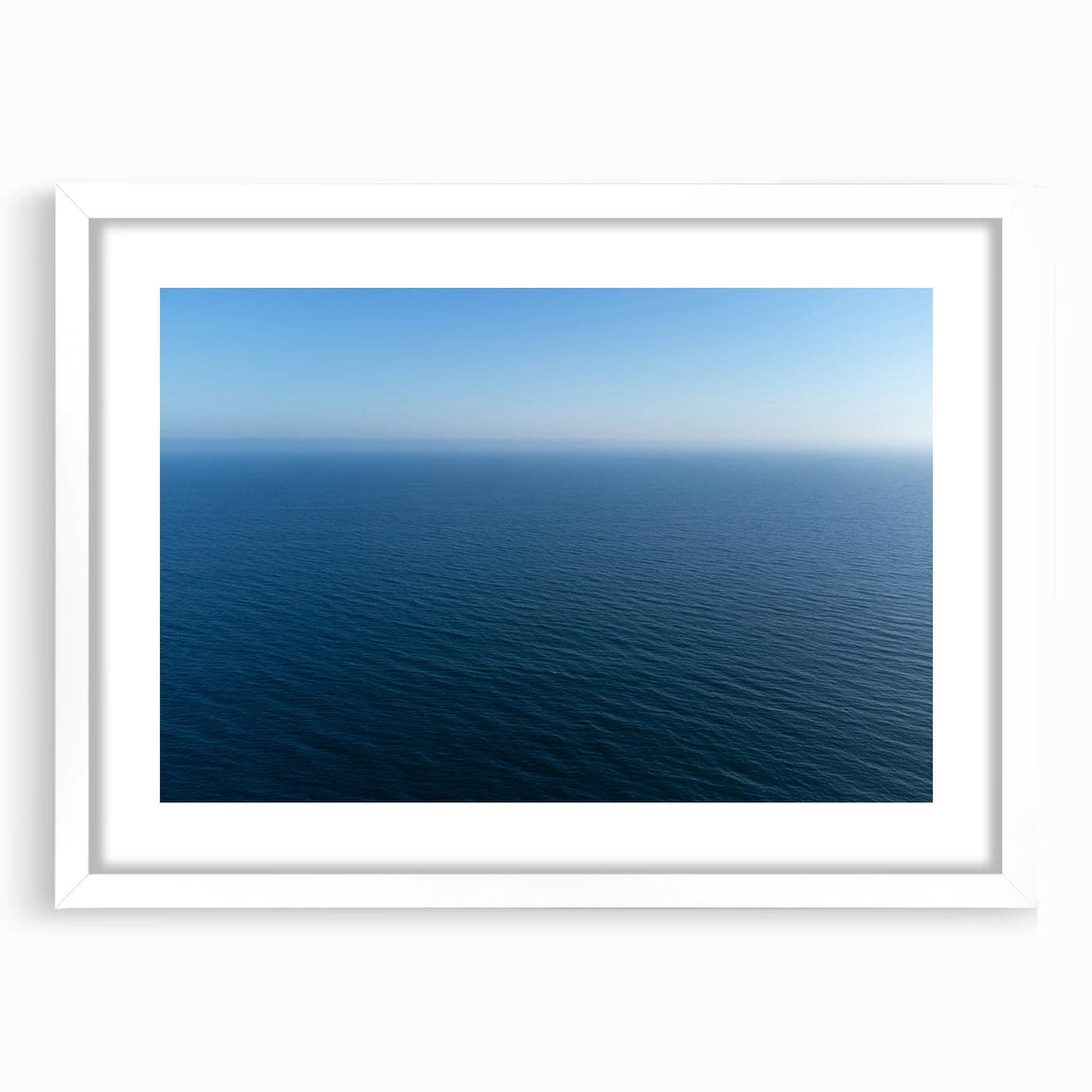 Abstract art print of Santa Monica scenery in muted blue and white tones on a framed canvas, suitable for dining room decor.