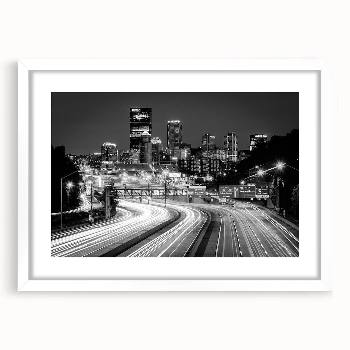 Abstract art print of Pittsburgh skyline in muted gray and blue tones on a framed white mat, ideal for dining room decor.