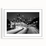 Abstract art print of Pittsburgh skyline in muted gray and blue tones on a framed white mat, ideal for dining room decor.