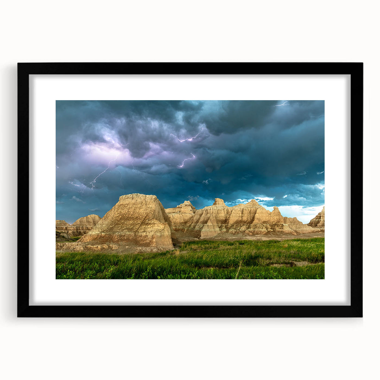 Colorful abstract art print of South Dakota Badlands in a large black frame, ideal for living room decor.