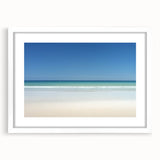 White-framed landscape print showcasing a serene beach scene with gentle waves and golden sand, perfect for coastal home decor. Ideal for enhancing living spaces.
