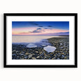 Black-framed landscape artwork depicting serene beaches with a mat, showcasing vibrant colors and a calming atmosphere, ideal for home decor or office setting.