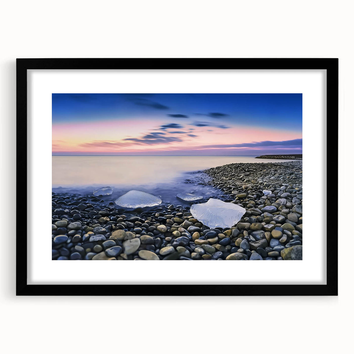 Black-framed landscape artwork depicting serene beaches with a mat, showcasing vibrant colors and a calming atmosphere, ideal for home decor or office setting.