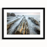 Black-framed landscape artwork featuring serene beach scenery with soft waves and golden sands, elegantly matted for a polished display, perfect for coastal home decor.