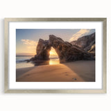 Framed landscape artwork depicting serene beaches with a silver mat border, showcasing soft blue and sandy tones, perfect for beach-themed decor.