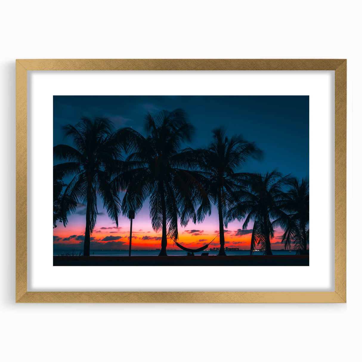 Textured abstract art print of Caribbean scenery in a gold frame, featuring muted ocean and sky tones.