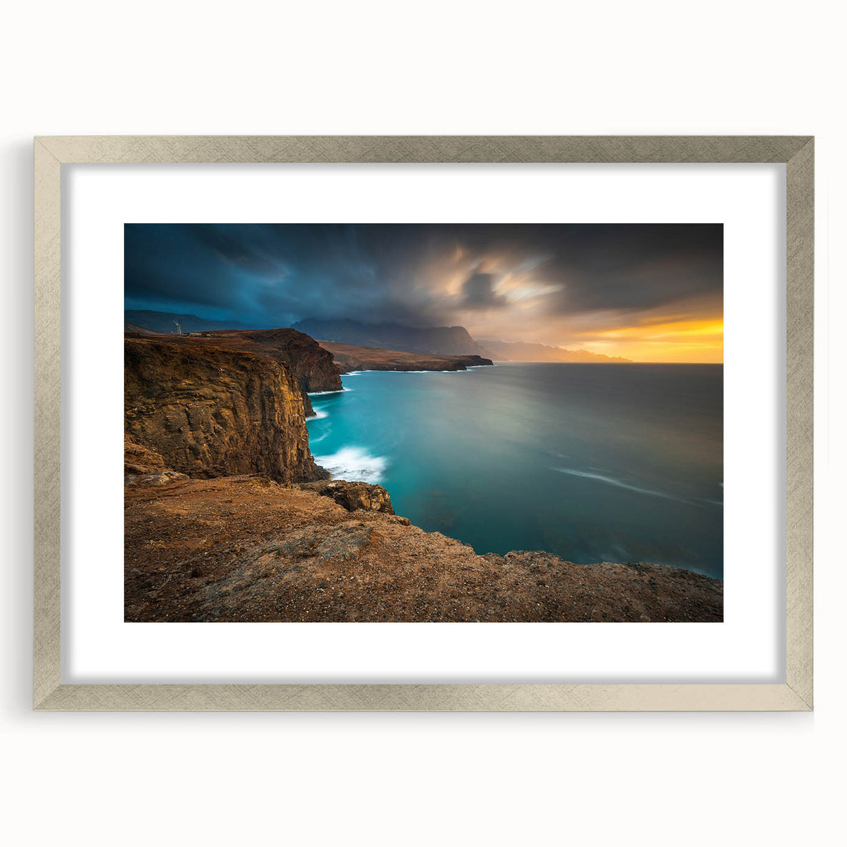 Extra large wall art depicting an abstract Caribbean scenery in textured hues of blue and green, framed in silver.